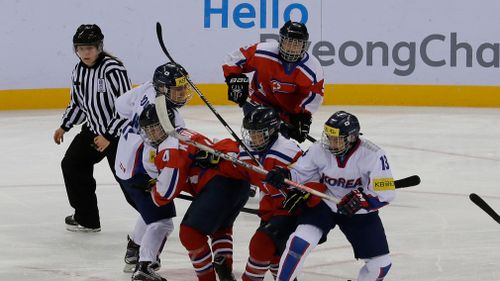 South Korea, wearing white uniforms, and North Korean players compete during their IIHF Ice Hockey Women's World Championship Division II Group A game in Gangneung, South Korea in April, 2016. (AAP)