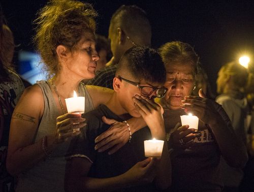 Mona Rodriguez holds her 12-year-old son, J Anthony Hernandez, during a candlelight vigil held for the victims of a fatal shooting at the First Baptist Church of Sutherland Springs. (AAP)