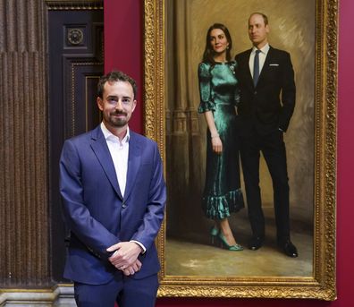 Award-winning portrait artist, Jamie Coreth poses in front of his painting of Britain's Prince William and Kate, Duchess of Cambridge as it is revealed to the public for the first time, in Cambridge, England, Thursday June 23, 2022.