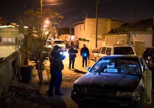 Police investigate the scene where a drug-related homicide occured in the city of Juarez.
