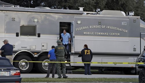 aw enforcement officials climb out a FBI mobile command center vehicle 