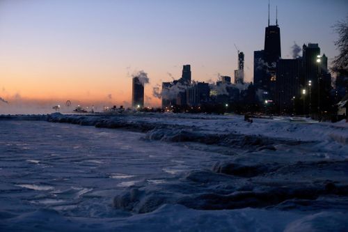 Ice forms along the shore of Lake Michigan before sunrise.
