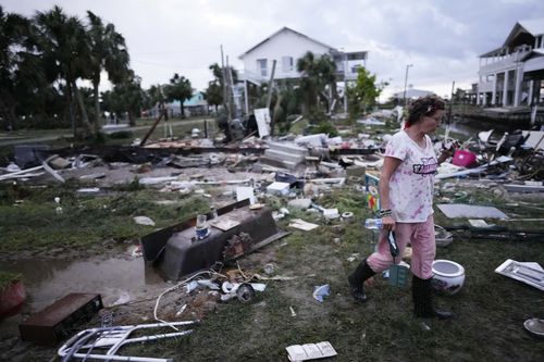 Jewell Baggett walks amidst debris strewn across the yard where her mothers home had stood, as she searches for anything salvageable from the trailer home her grandfather had acquired in 1973 and built multiple additions on to over the decades, in Horseshoe Beach, Fla., after the passage of Hurricane Idalia, Wednesday, Aug. 30, 2023. 