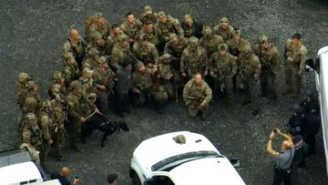 Police posed for a photo with the captured fugitive after his capture.