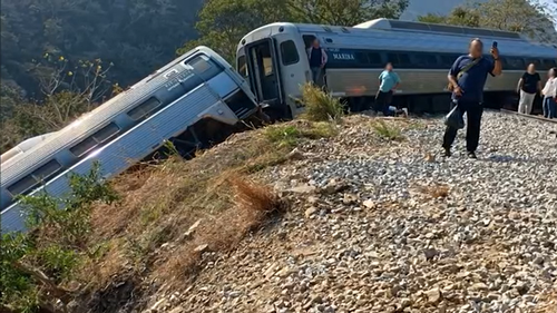 Passageiros foram vistos nos trilhos da ferrovia após escaparem do trem acidentado.