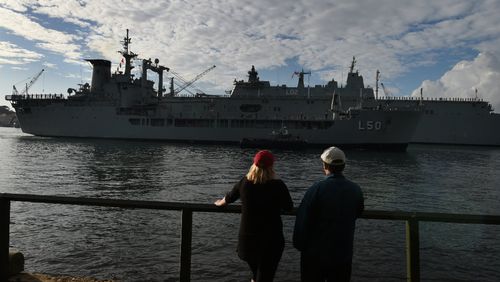 Early morning walkers watch as Australian Naval ship HMAS Tobruk arrives at Garden Island. Picture: AAP