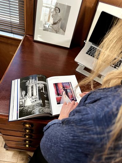Camera Press owner and co-director Emma Blau flips through pages of the photo book Queen Elizabeth II: A Photographic Portrait by Thames & Hudson
