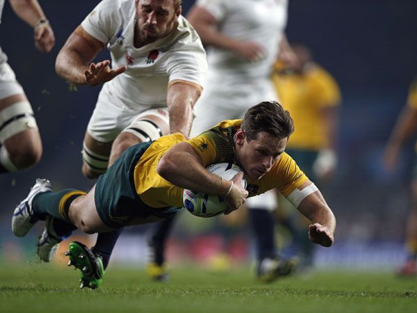 Wallbies flyhalf Bernard Foley dives over for his second try against England. (AFP