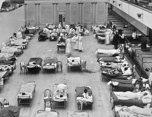 Volunteer nurses from the American Red Cross tend to influenza patients in the Oakland Municipal Auditorium, used as a temporary hospital.