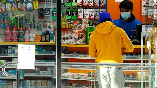 A shop attendant is seen wearing a face mask on August 02, 2020 in Melbourne, Australia. (Photo by Darrian Traynor/Getty Images)