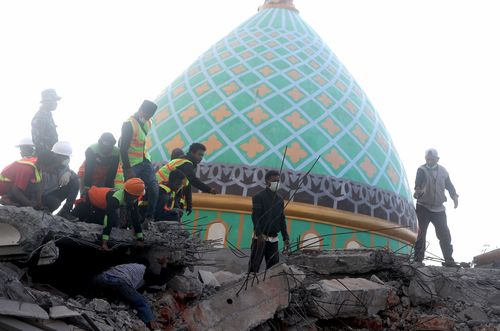 Indonesian rescuers uncovered two survivors from a pancaked mosque left behind from the Lombok earthquake that rattled the region over the weekend. Picture: AP.