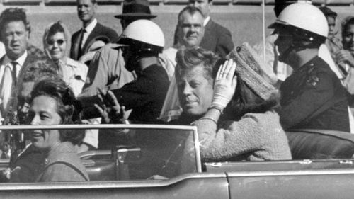 President John F. Kennedy waves from his car in a motorcade in Dallas on November 22, 1963. (AP)