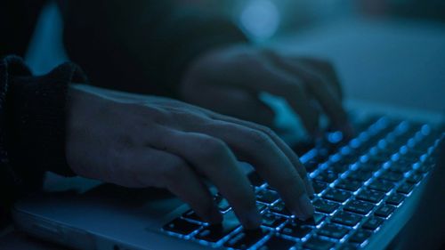 A person types on a laptop keyboard