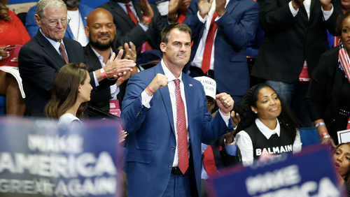 FILE - In this June 20, 2020 file photo, Oklahoma Gov. Kevin Stitt is recognized as President Donald Trump speaks during a campaign rally at the BOK Center, in Tulsa, Okla. Stitt announced Wednesday, July 15, 2020, that he's tested positive for the coronavirus and that he is isolating at home. The first-term Republican governor has backed one of the country's most aggressive reopening plans, has resisted any statewide mandate on masks and rarely wears one himself. (AP Photo/Sue Ogrocki, File)