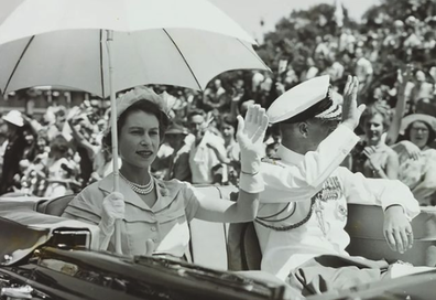 The Queen and The Duke of Edinburgh wave to crowds as they travel to Parliament House, Brisbane, Australia in 1954.