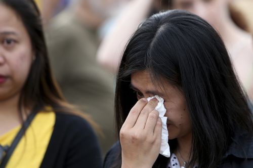 A woman cries as she attends a memorial for the victims at the mineshaft where two female bodies were found. (AP Photo/Petros Karadjias)