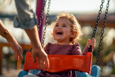 Adorable little girl having fun on a swing.