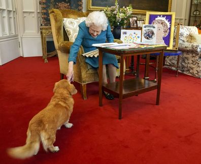 EMBARGOED TO 1800 GMT Friday February 4, 2022. Queen Elizabeth II is joined by one of her dogs, a Dorgi called Candy, as she views a display of memorabilia from her Golden and Platinum Jubilees in the Oak Room at Windsor Castle. Issue date: Friday February 4, 2022. PA Photo. The Queen has since travelled to her Sandringham estate where she traditionally spends the anniversary of her accession to the throne - February 6 - a poignant day as it is the date her father King George VI died in 1952. Se