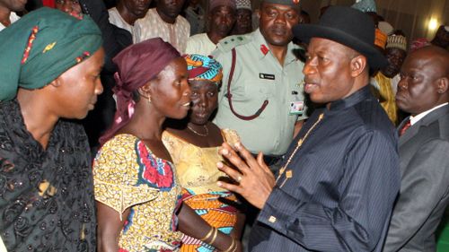 Nigerian President Goodluck Jonathan speaks to some of the Chibok schoolgirls who escaped Islamist captors and relatives of the hostages during a meeting.