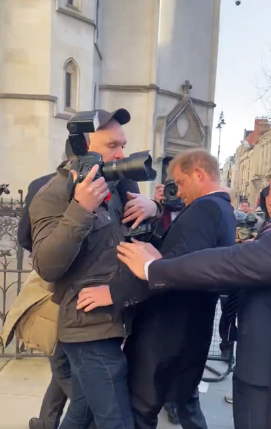 Prince Harry bumps into a photographer as he arrives at the High Court in London on Monday March 27, 2023.