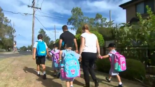 The three girls make their way to school with their parents. (9NEWS)