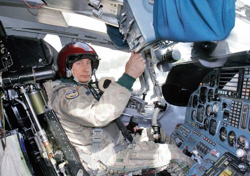 Russian President Vladimir Putin wearing a jump suit sits in the cockpit of a sleek white Tu-160 bomber in 2005. 