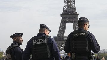 Police officers patrol the Trocadero plaza near the Eiffel Tower in Paris, Tuesday, Oct. 17, 2023.