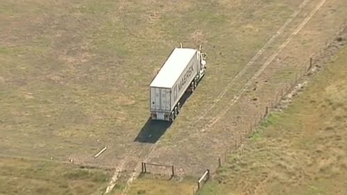 A semi-trailer can be seen in a nearby field. (9NEWS)