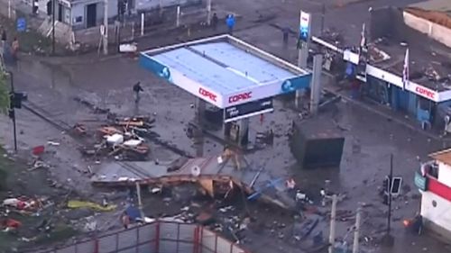 Debris surrounds a fuel station.