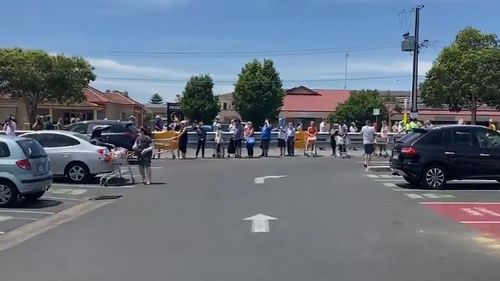 People lining up outside a supermarket in Adelaide.