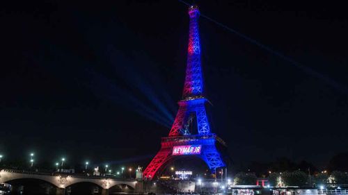 The Eiffel Tower was lit up with the colours of football team Paris Saint Germain. (AAP)
