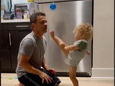 Baby kicking a ball out of his dad's mouth