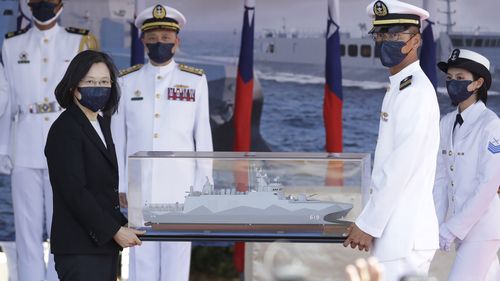 Taiwan's President Tsai Ing-wen, left, holds a model ship during the commissioning ceremony of the the domestically made Ta Jiang warship. 