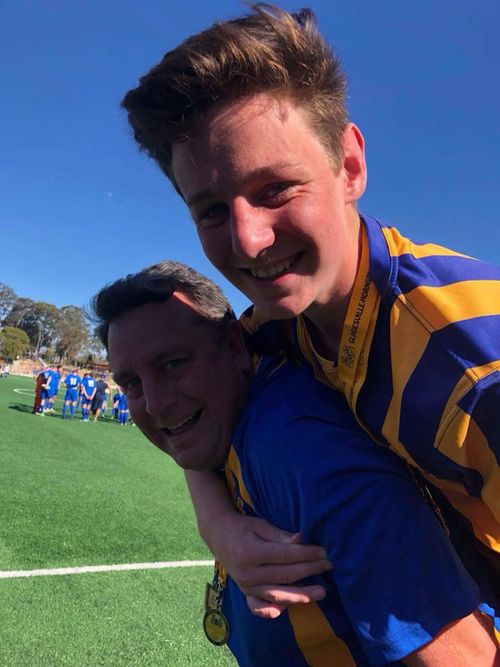 14-year-old Dylan Langhorne and his father after a football game.