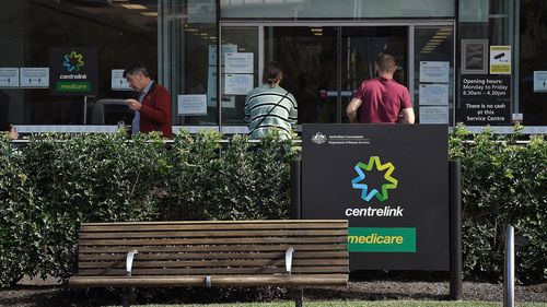 People wait outside a Services Australia outlet