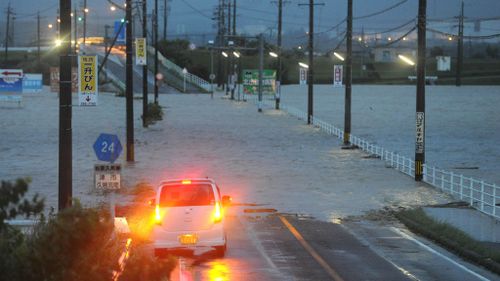A car is stalled at a flooded road in Tsu, as Typhoon Halon brought heavy rain. The typhoon smashed Japan causing municipal authorities to order for evacuation living near rivers and seashore areas. (The Yomiuri Shimbun via AP Images )