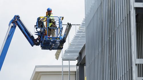 Construction worker works outside of commercial building site during a hot weather in Mount Prospect, Illinois.