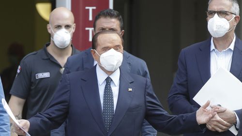 Italian former Premier Silvio Berlusconi is flanked by his personal physician Alberto Zangrillo, right, as he leaves the San Raffaele hospital in Milan, Italy, Monday, Sept. 14, 2020