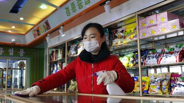 An employee of the Kyonghung Foodstuff General Store disinfects the showroom countertops in Pyongyang, North Korea in November 2021.