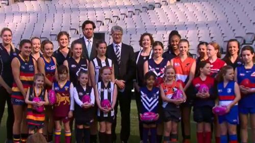 AFL CEO Gillon McLachlan and Chairman Mike Fitzpatrick with girls football players from the eight teams. (9NEWS)