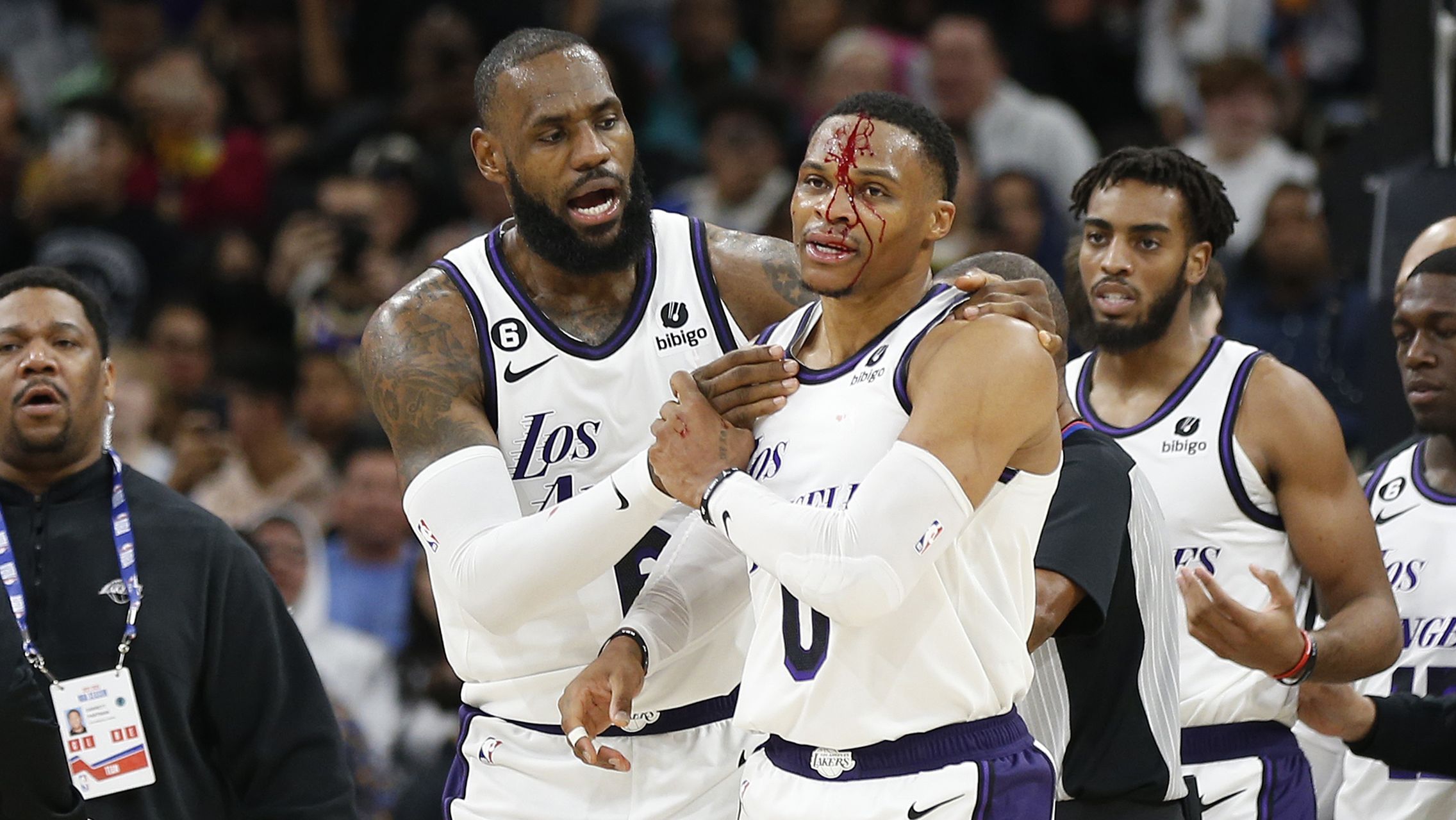 LeBron James checks on Russell Westbrook after he received a hit on a drive to the basket by Zach Collins.