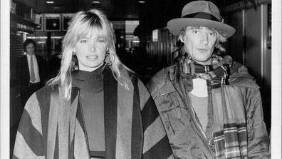 Rod Flies The Tartan Flag -- Rod Stewart and Kelly Emberg.  Rod Stewart was proudly flaunting a long tartan scarf when he turned up at London airport on Monday19th November 1984, with girlfriend Kelly Emberg. The rock star had been in Britain to see his favourite team Scotland beat Spain in the World Cup. Rod, who was off to Los Angeles to prepare for a terra tour of Japan, said: "I'll be coming back for Christmas." He hit out at reports that his former wife Alana is living with tennis star John