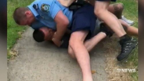 Video of the arrest shows officers pushing Wiles to the ground and holding his head to the footpath. 