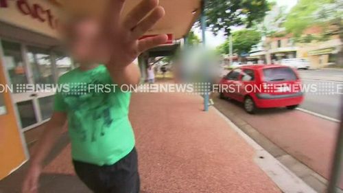 The son of the accused woman scuffles with the media outside court. (9NEWS)