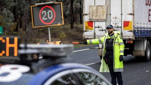 Victoria Police check vehicles heading south bound at the Chiltern temporary traffic management point on the Hume Highway.