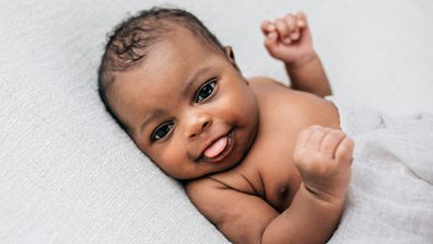 Beautiful newborn little boy just a few weeks old swaddled in a cream colored soft blanket with copy space