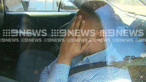 The man accused of staring into a family home in Collaroy is escorted to Manly Police Station.