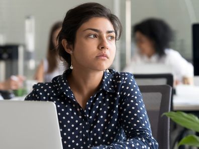 Woman sitting pensively at desk