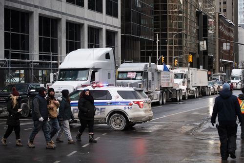 Trucks are parked on O'Connor Street as a rally against COVID-19 restrictions, which began as a cross-country convoy protesting a federal vaccine mandate for truckers, continues in Ottawa, Ontario, on Sunday, Jan. 30, 2022 