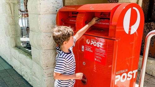 Australia Post child posting letter.